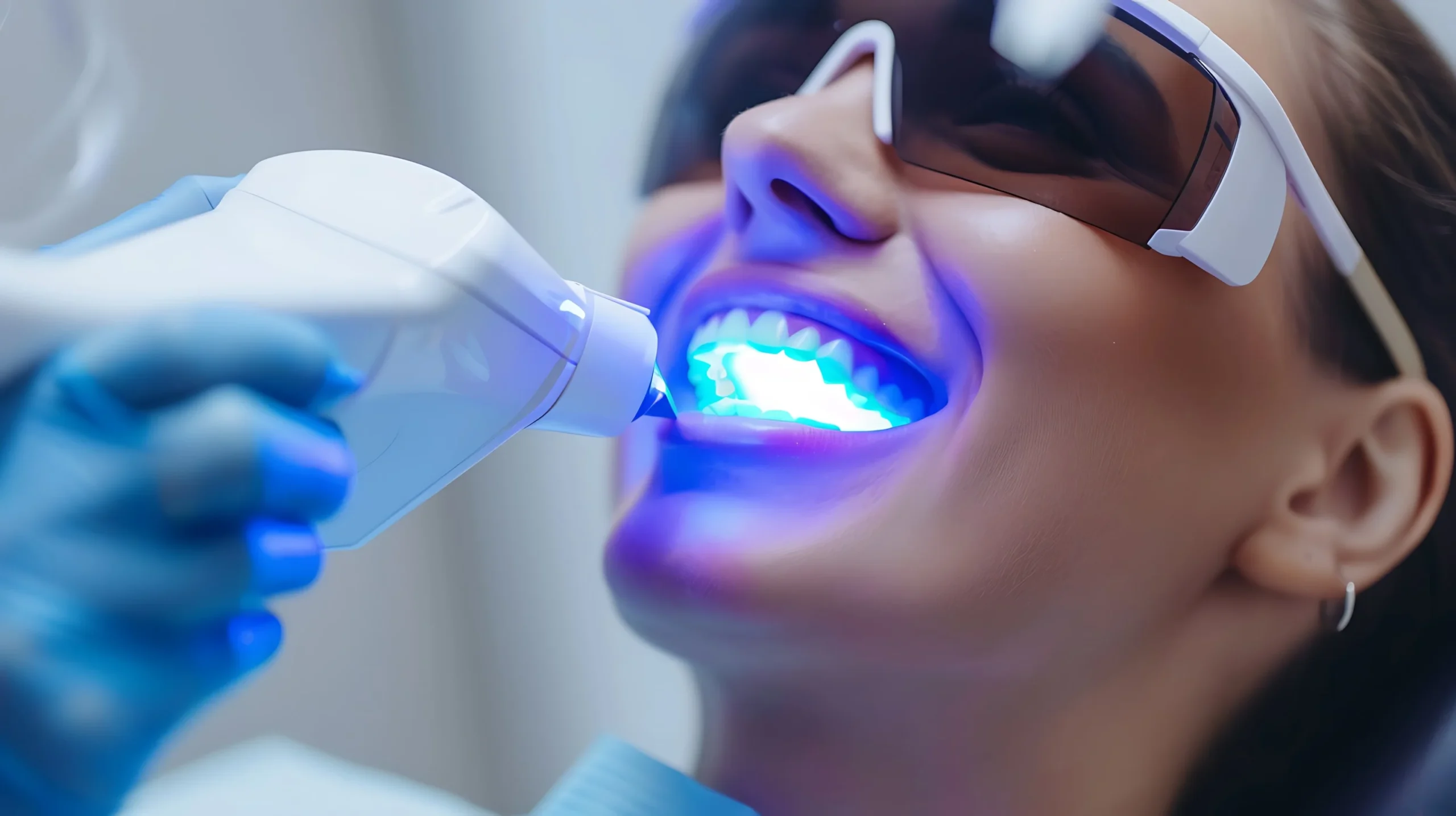 Professional teeth whitening procedure with a whitening light